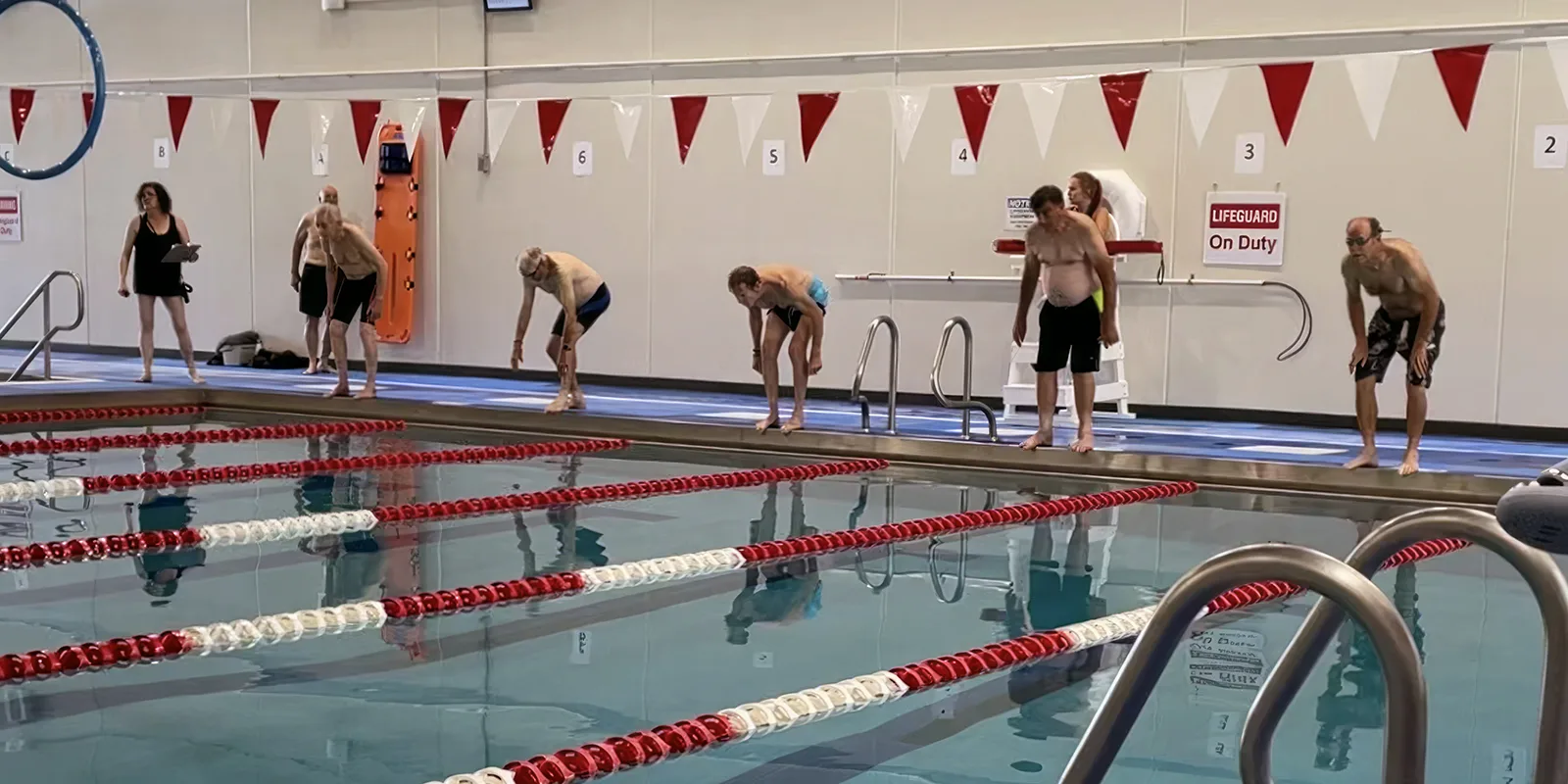 Swimmers lined up on the pool deck preparing to dive at a Turners swim meet
