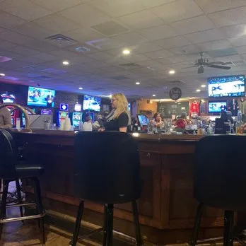 A bartender serving behind the bar in the Aurora Turners lounge