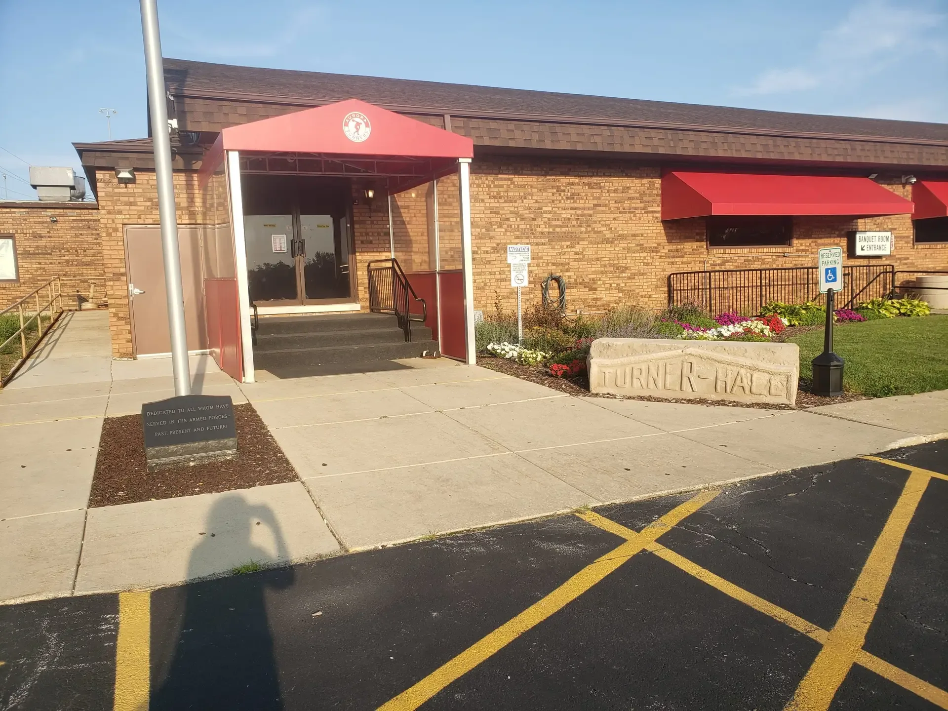 The brick entrance to Aurora Turner Hall with red awnings and an engraved Turner Hall stone