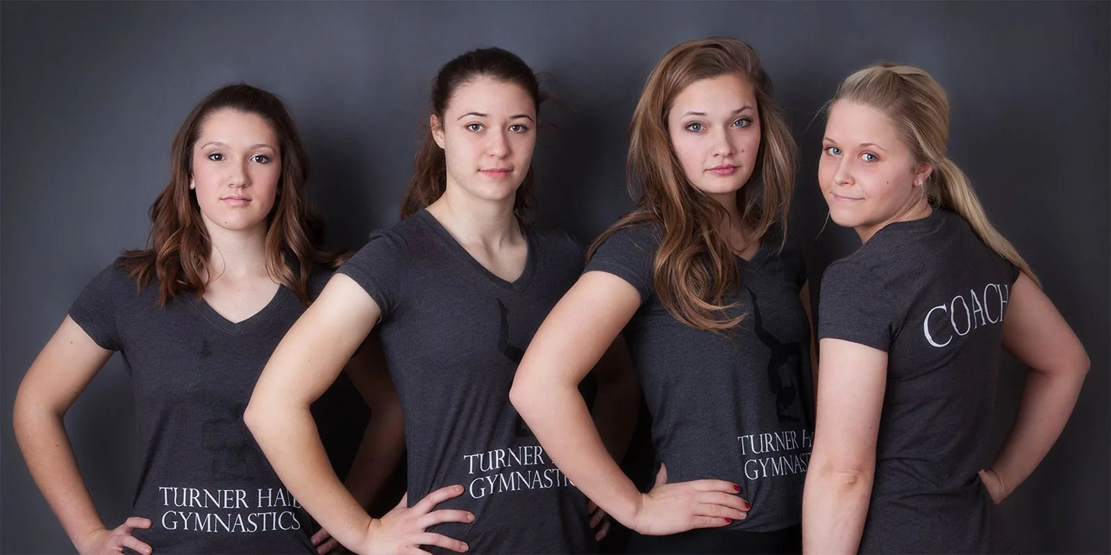 Four Turner Hall Gymnastics team members and a coach in team shirts